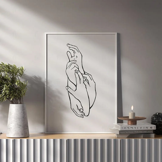 Plakat z czarno-białą grafiką line art przedstawiającą dwie dłonie w geście delikatnego dotyku. w salonie