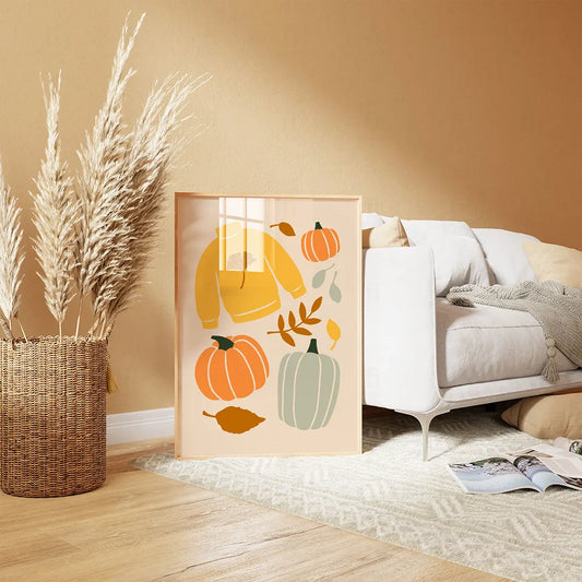 kompozycja graficzna z żółtym swetrem, trzema dyniami  