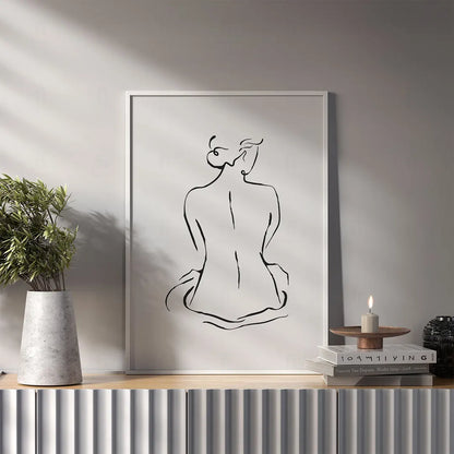 Plakat z czarno-białą grafiką line art przedstawiającą zarys kobiecej postaci / sylwetki. w salonie