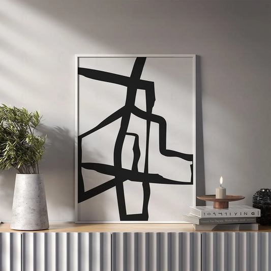 Plakat z czarno-białą, abstrakcyjną grafiką przedstawiającą przecinające się geometryczne kształty wiszący w salonie
