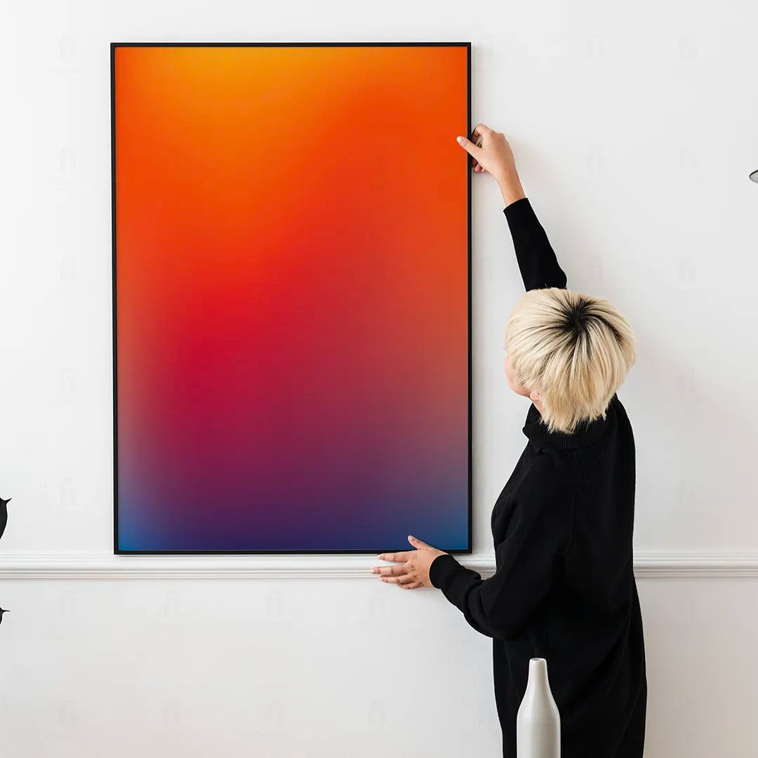 Plakat z abstrakcyjną grafiką przedstawiającą rozmyty gradient w ciepłych odcieniach pomarańczu, różu i żółci.
