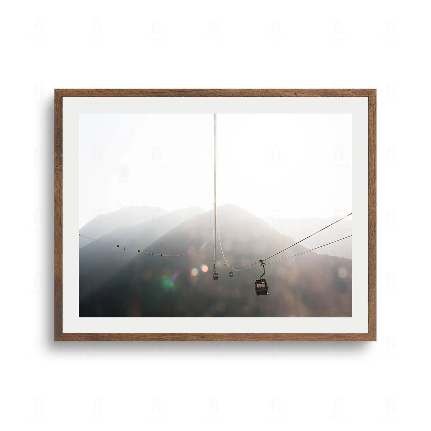 Kolejka linowa z wagonikami we mgle nad górskimi szczytami w promieniach słońca.