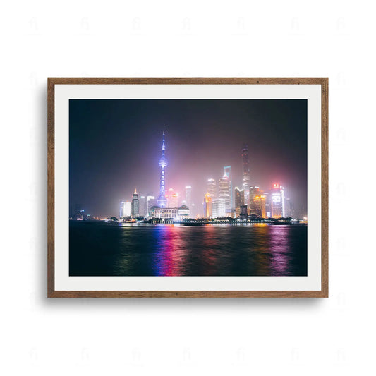 Nocna panorama Szanghaju z oświetloną wieżą Oriental Pearl Tower i nowoczesnymi drapaczami chmur odbijającymi się w rzece.